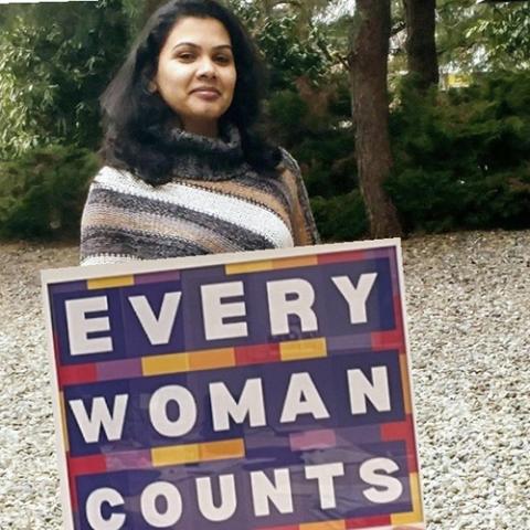 Holding sign Every Woman Counts
